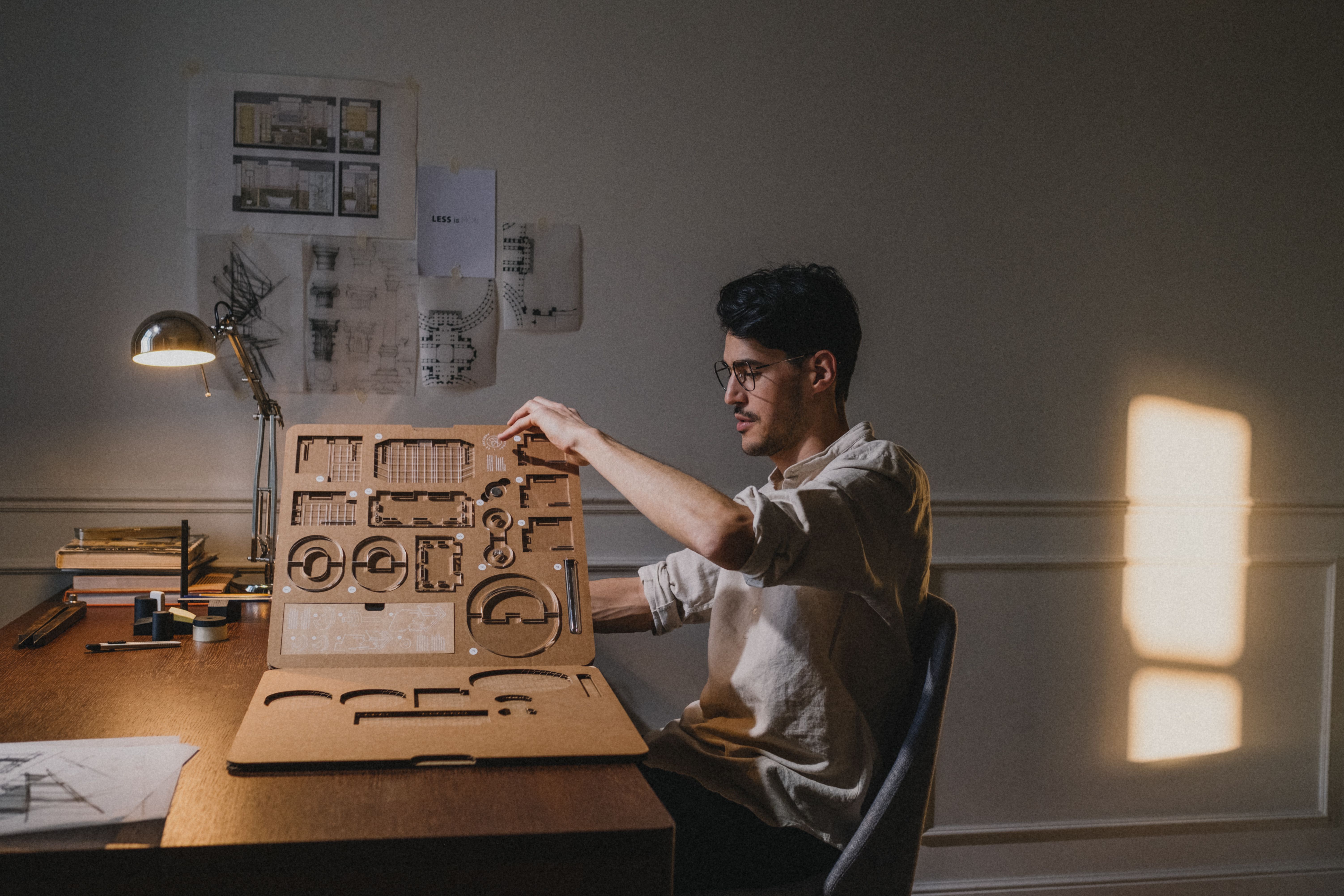 A designer working on a model at a desk in a home workspace
