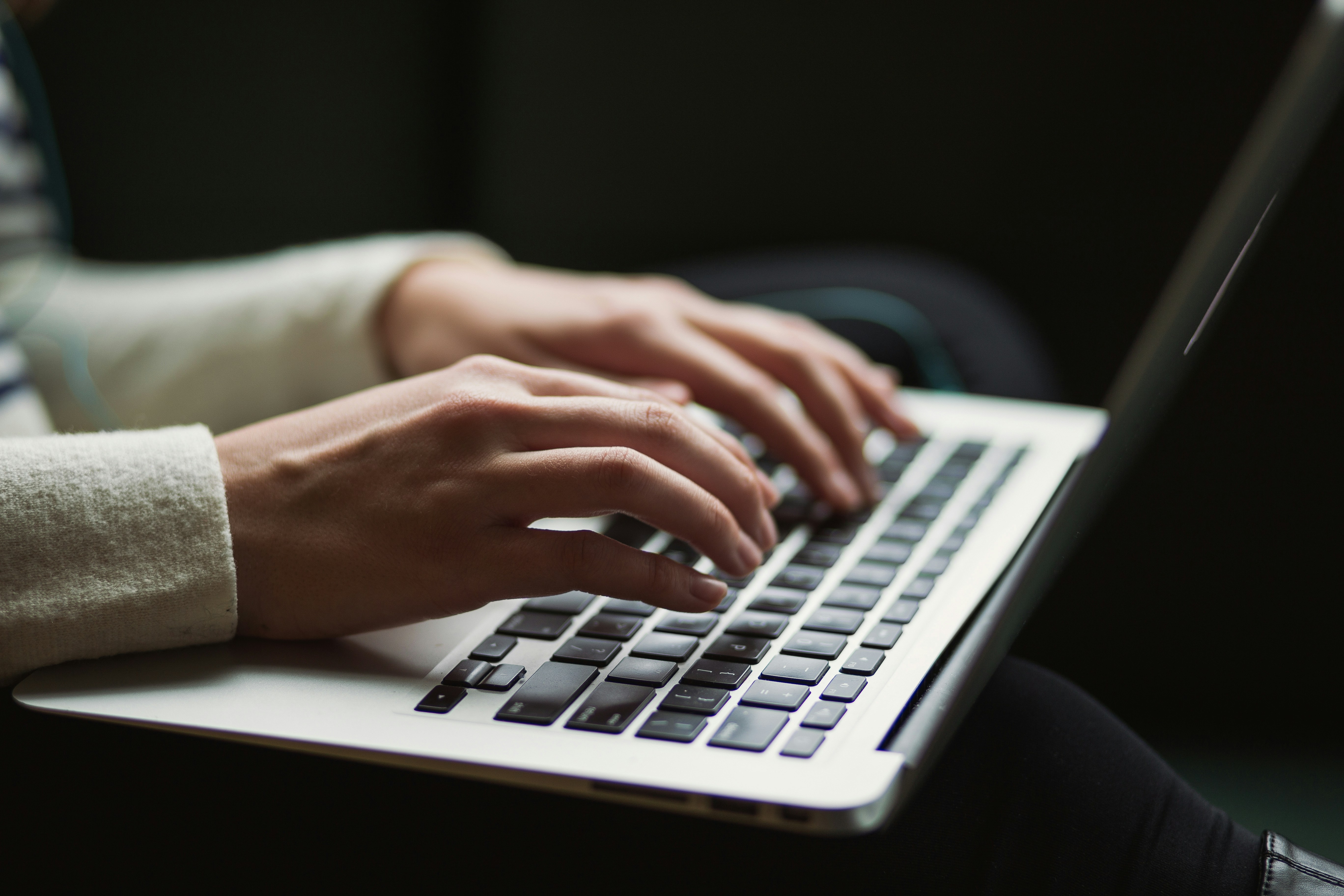 A person typing on a laptop computer