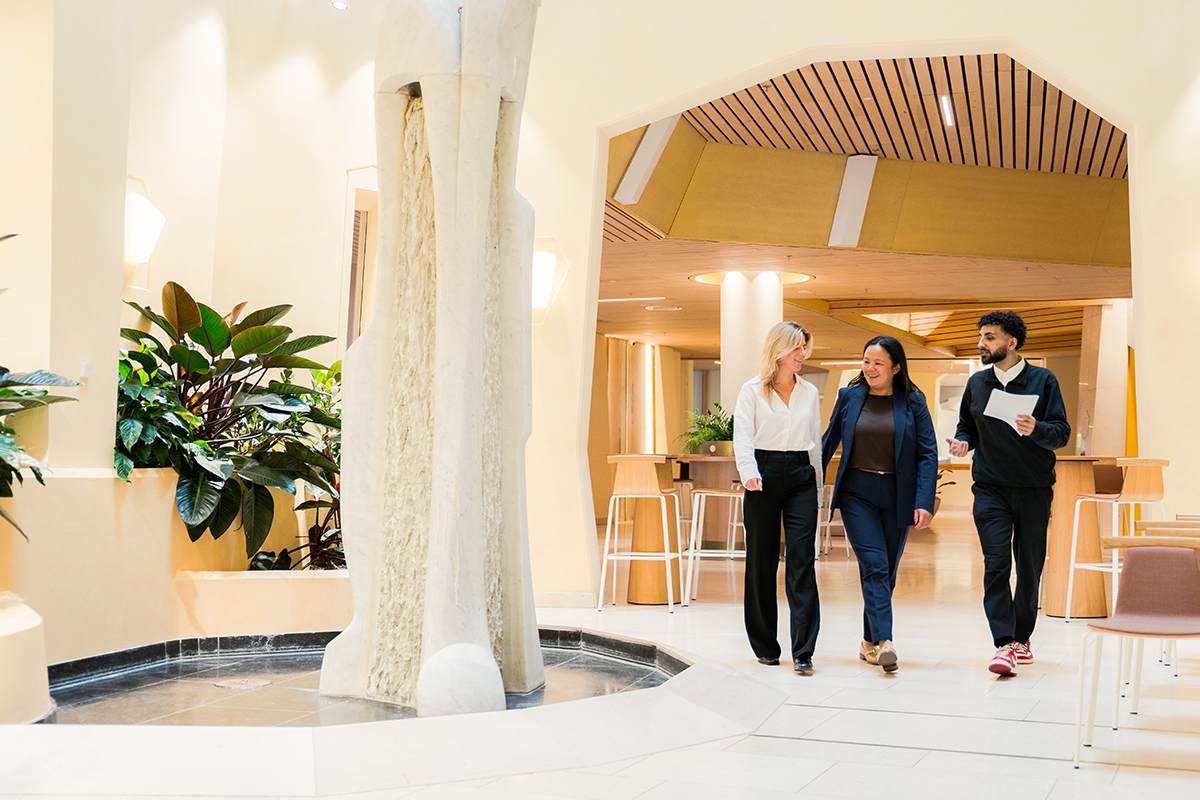Three professionals walking through a bright office in a photograph supplied by Levy Global