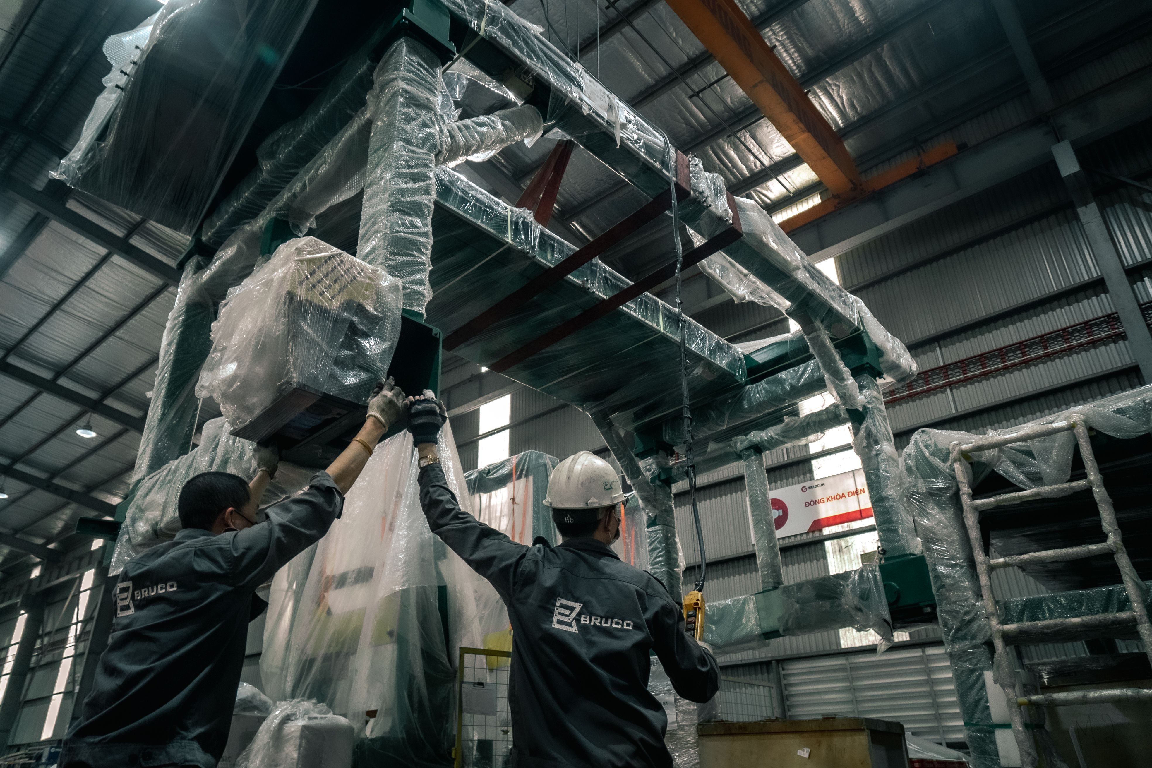 Careers in building materials Workers installing machinery in an industrial warehouse.