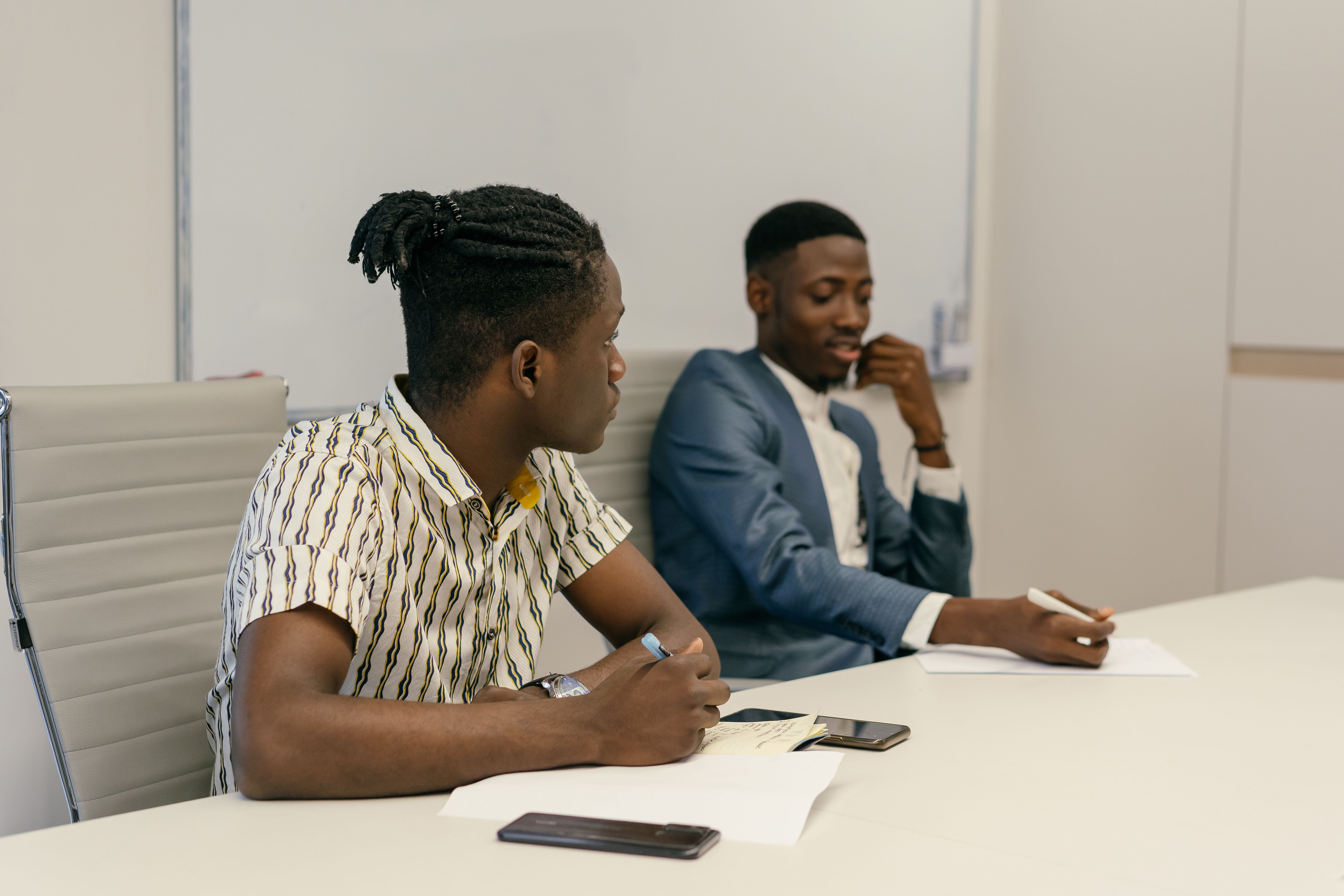 Two colleagues discussing work in an office; illustrative stock photo