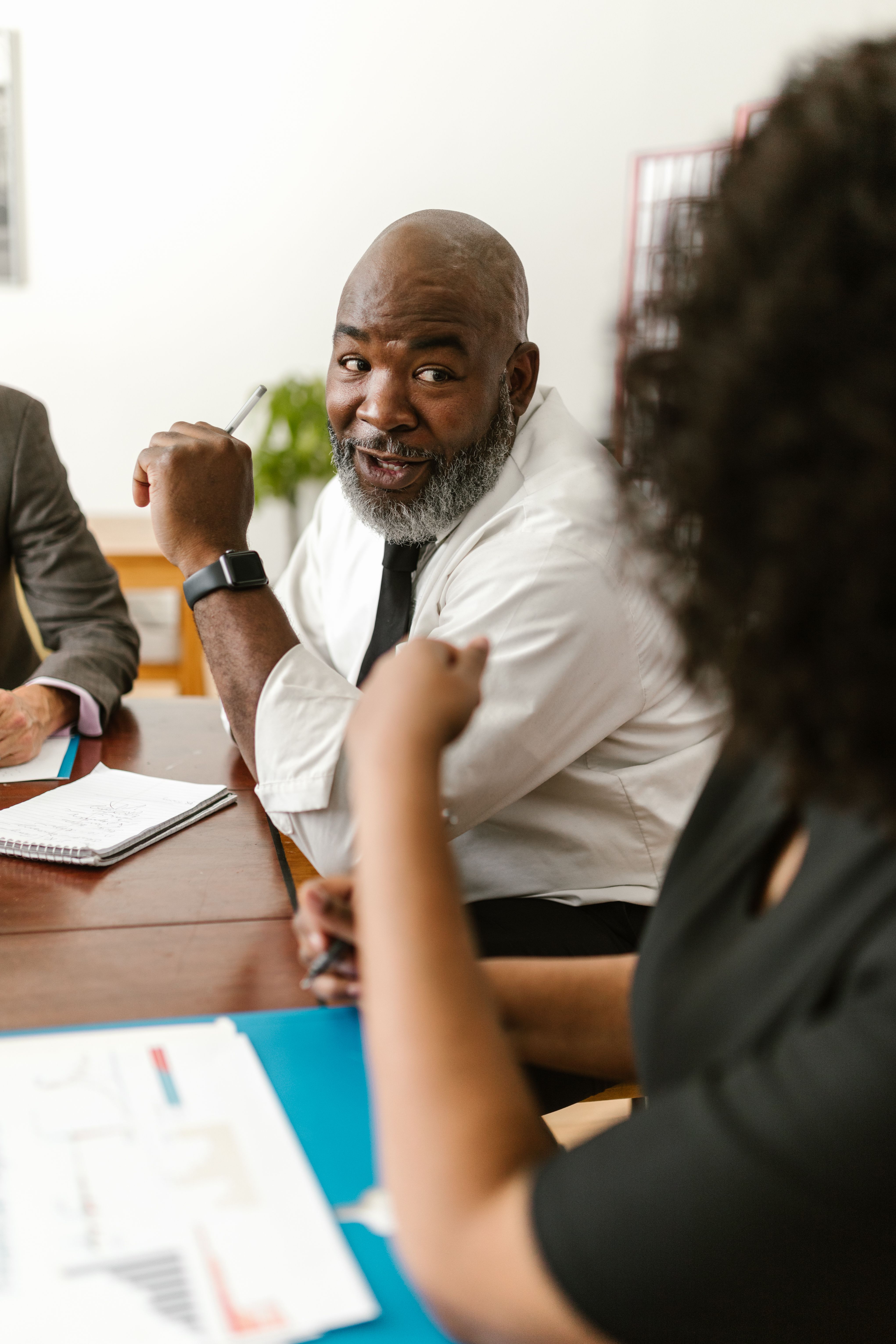 Colleagues discussing documents at an office meeting; illustrative stock photo
