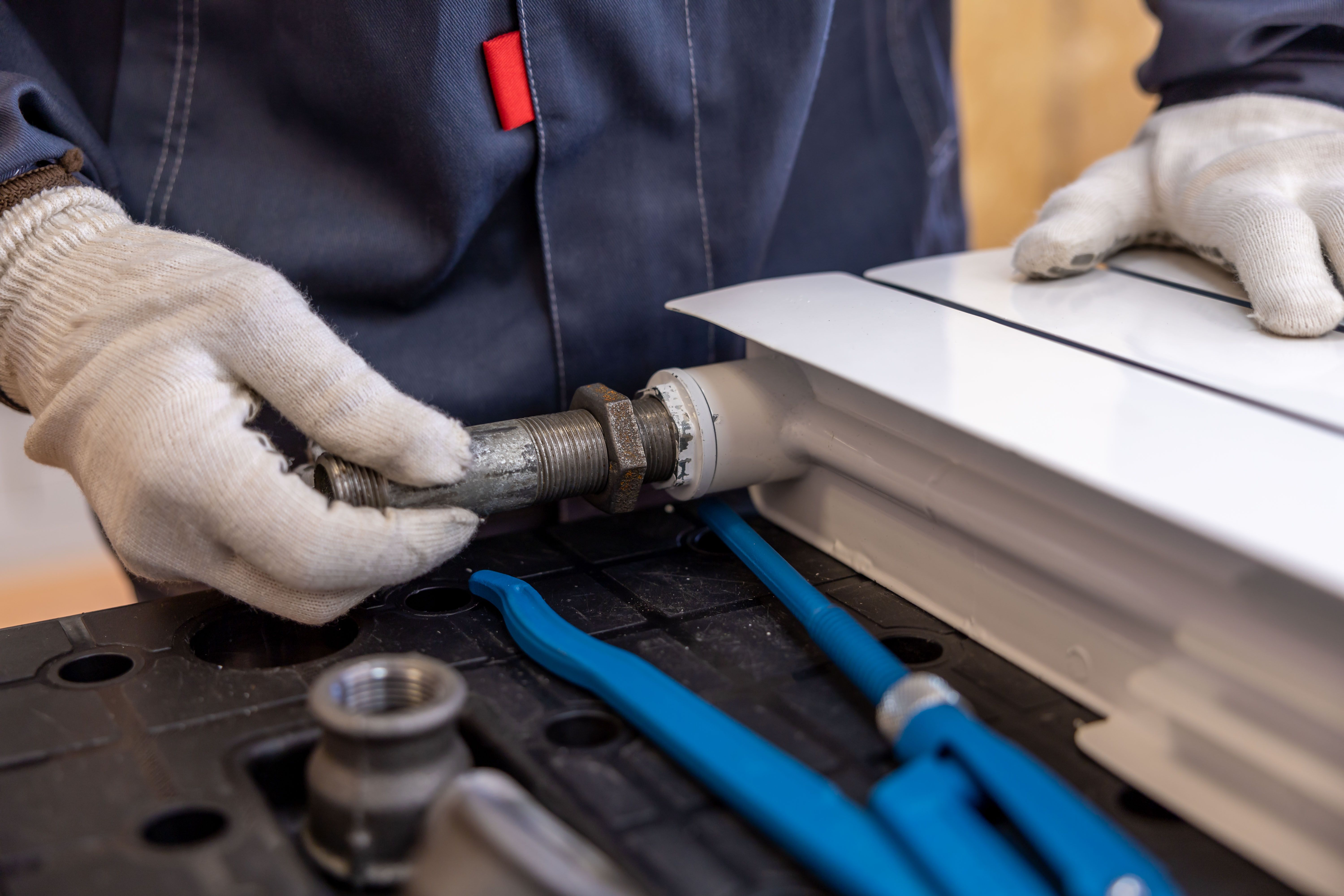 Skilled trades plumbing work Plumber installing a radiator pipe using specialised tools