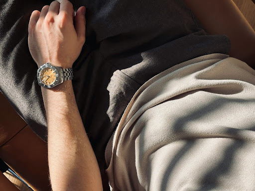 Rest and recovery as part of a resilient work-life balance A person resting comfortably on a couch with a watch visible, symbolising recovery, downtime, and the importance of rest after work stress.
