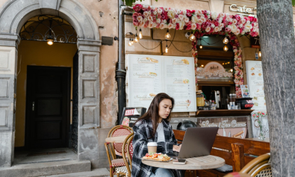 Woman working on a laptop at an outdoor café — photo by MART PRODUCTION, Pexels