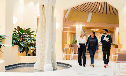 Three professionals walking through a bright office in a photograph supplied by Levy Global