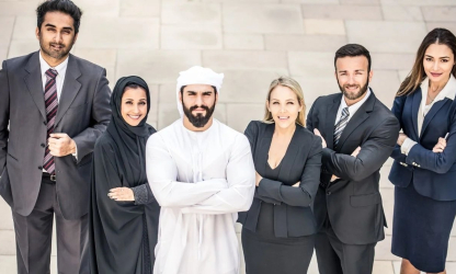 Six business professionals standing together outside a modern building
