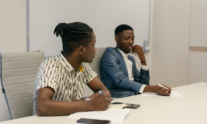 Two colleagues discussing work in an office; illustrative stock photo