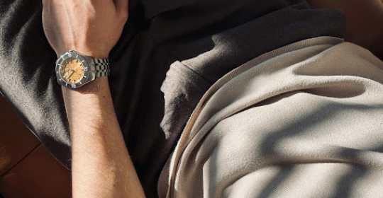 A person resting comfortably on a couch with a watch visible, symbolising recovery, downtime, and the importance of rest after work stress.