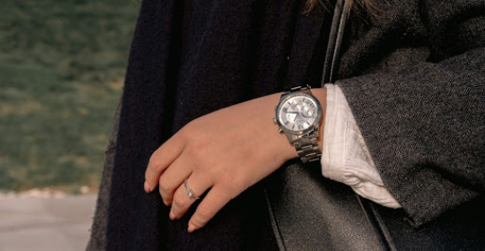 Close-up of a person wearing a classic wristwatch and ring, symbolising timeless accessories and understated professional style.