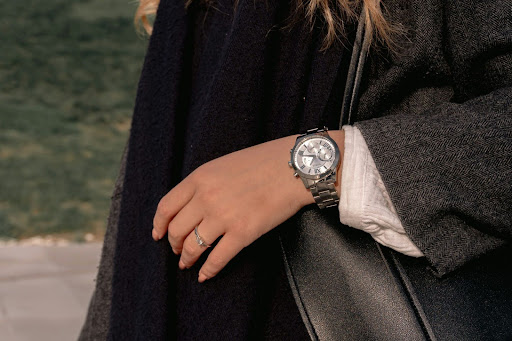 Close-up of a person wearing a classic wristwatch and ring, symbolising timeless accessories and understated professional style.